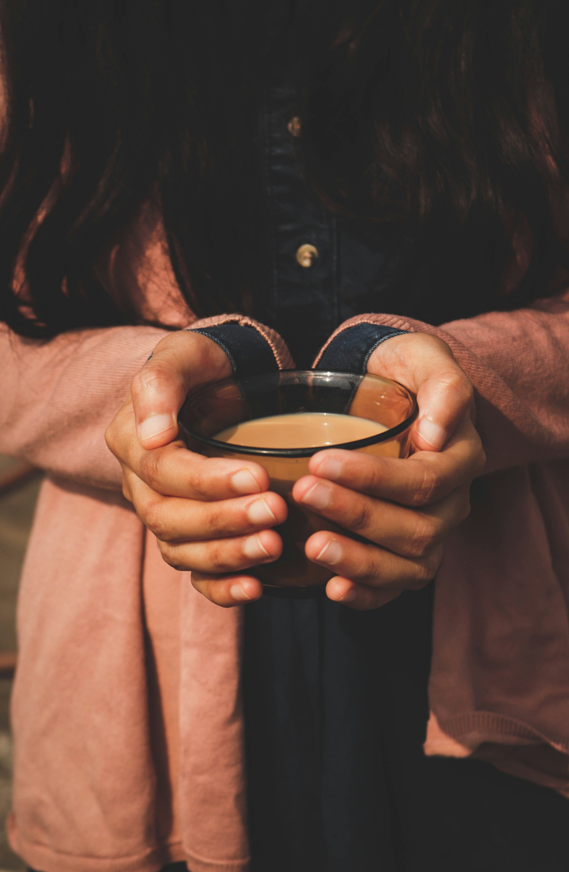 A woman holding a warm cup of tea in quiet reflection